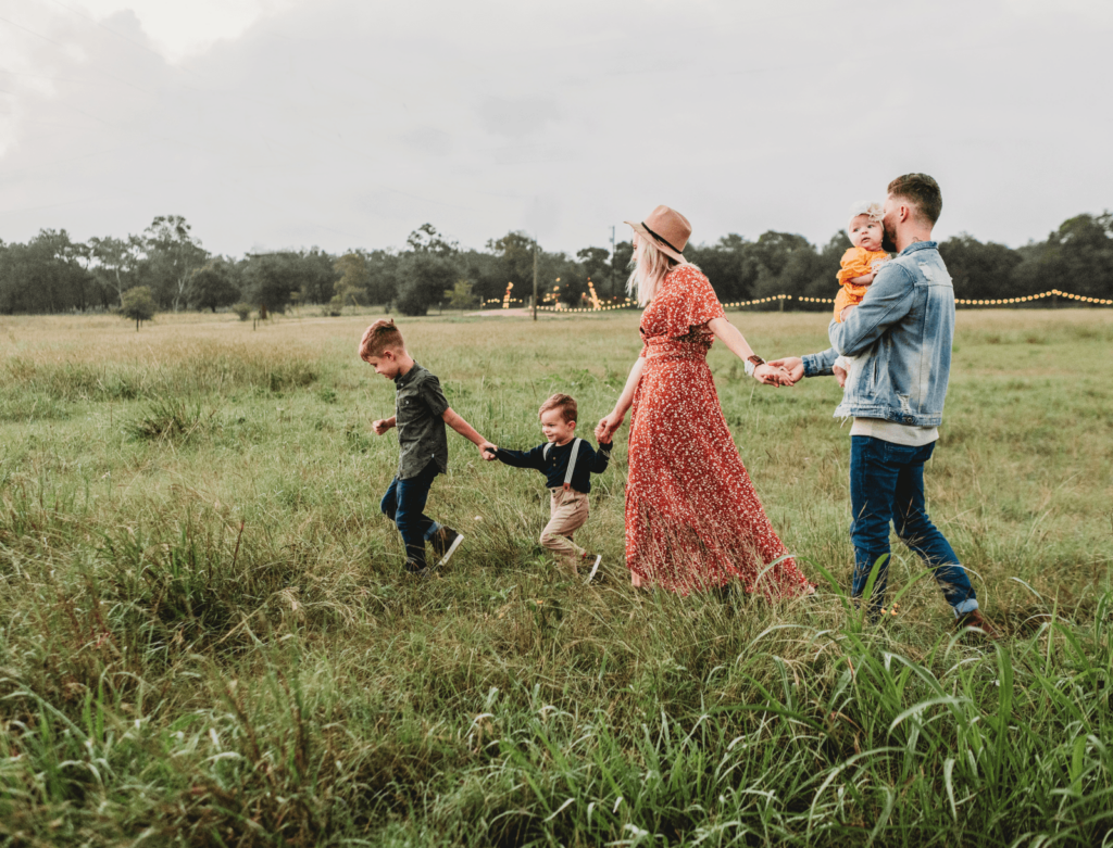 Family walking through a meadow with tall grass