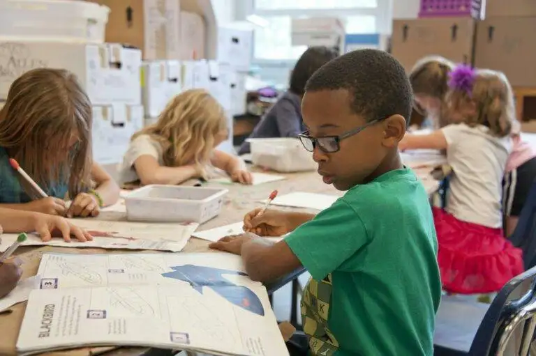 Boy and other kids at Loudoun County schools draw artwork at a table