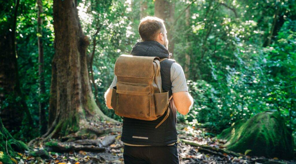 Man carrying a backpack while hiking Lansdowne on the Potomac community nearby parks and trails recreation by top local realtor real estate agents the Jean Garrell Group