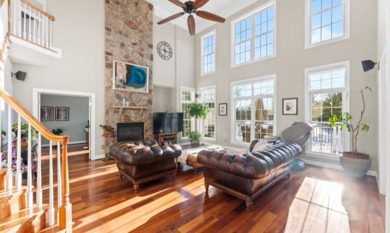 Dramatic two-story living room with large fireplace in Leesburg Lansdowne home for sale by the best real estate listing agents in Loudoun County