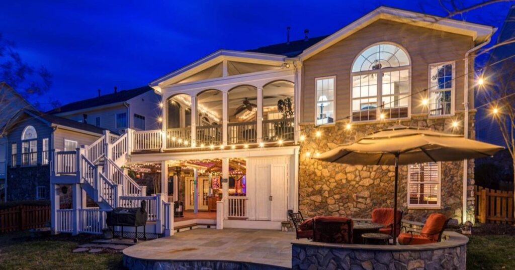 Backyard patio at night with exterior lighting and patio dining set, sold by the best realtors in Loudoun County at the Jean Garrell Group