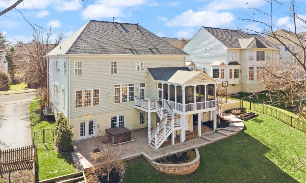 Drone photo of the rear of a large home and backyard in Lansdowne, Loudoun County, VA, listed for sale with the best local real estate agents for sellers
