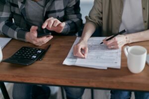 Man and woman at a table with paperwork and calculator for Loudoun County property tax and homeowners information in Northern Virginia