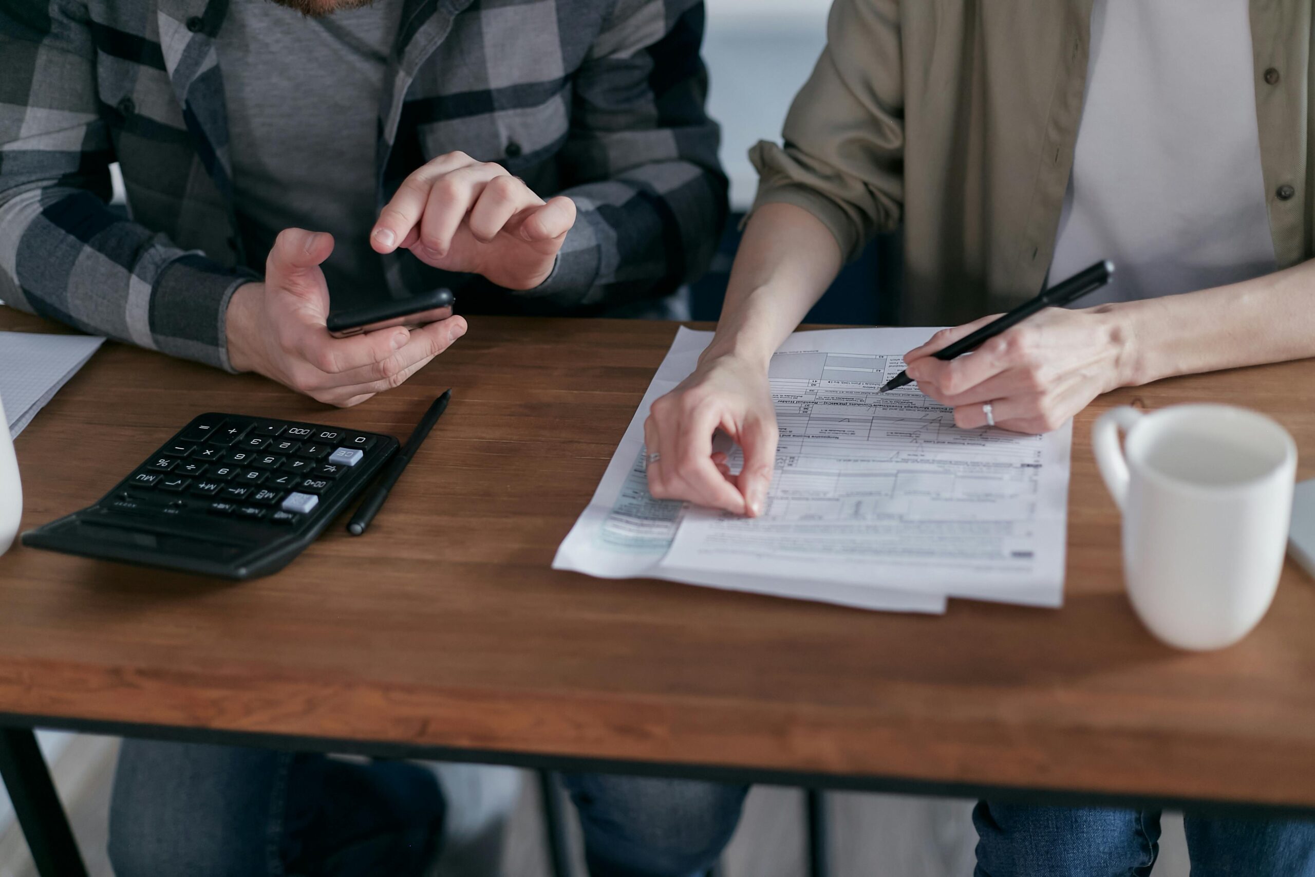 Man and woman at a table with paperwork and calculator for Loudoun County property tax and homeowners information in Northern Virginia