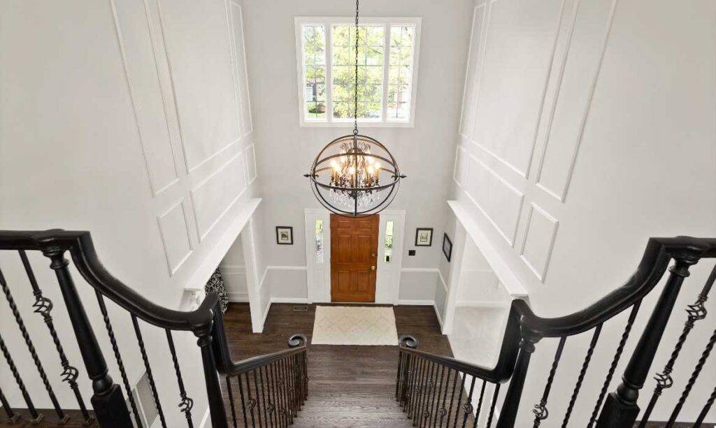 View from above a staircase to a two-story foyer in a luxury home perfect for relocating professionals who plan moving to Loudoun County, Virginia