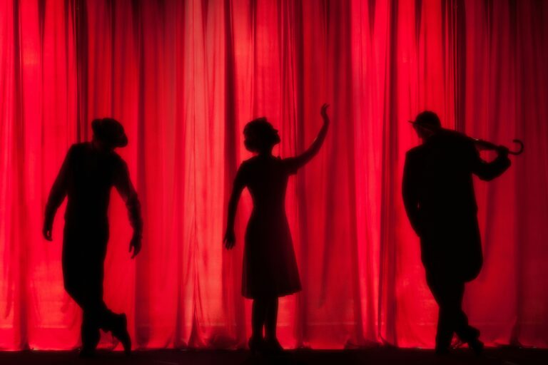 Silhouettes of performers on stage representing live theater near Dulles
