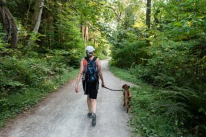 Two women walking a dog on a neighborhood path representing pet-friendly living in Sterling Virginia