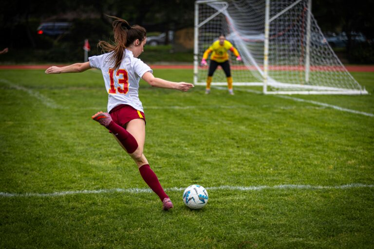 Female soccer player kicking a ball toward the goal, representing youth sports near Potomac Falls, Virginia.