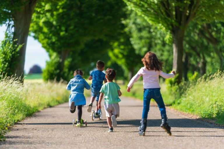 Children riding scooters and rollerblading outdoors to show the variety of family fun in Potomac Falls, Virginia.