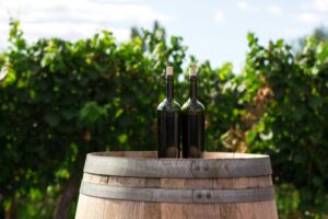 Wine bottles on a wooden barrel representing Purcellville wineries and local vineyards in Virginia.